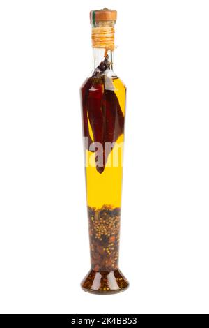 Glasflasche mit erstklassigem nativem Olivenöl mit Gewürzen und Kräutern. Isoliert auf weißem Hintergrund. Chili Olivenöl. Olivenöl mit Paprika oder rotem Pfeffer. Stockfoto