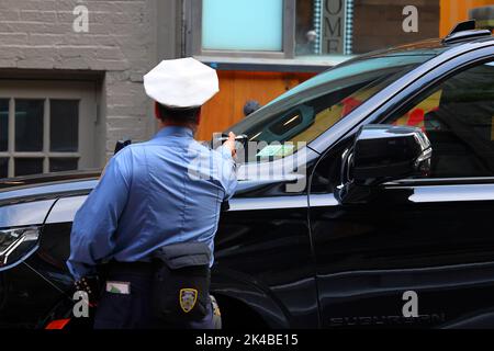 Ein Mitarbeiter der Verkehrsbehörde von NYC scannt eine Kfz-Registrierung mit einem tragbaren drahtlosen Gerät, das den Echtzeitzugriff auf Parkscheine ermöglicht Stockfoto