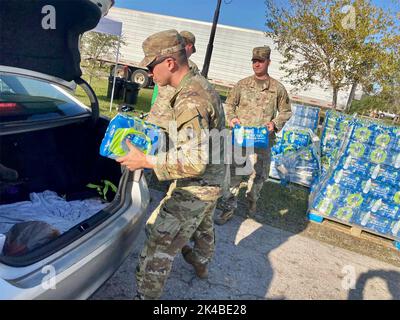 Fort Myers, Usa. 01. Oktober 2022. Soldaten der US-Armee mit dem 1-124.-Bataillon laden nach dem katastrophalen Hurrikane Ian am Flea Market Fun Verteilungspunkt am 1. Oktober 2022 in Fort Myers, Florida, Wasserflaschen in ein Fahrzeug. Kredit: 1. Sgt. Rachel Cabanting/National Guard Foto/Alamy Live News Stockfoto