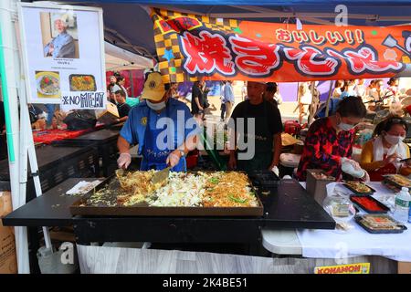 Ein Koch bereitet auf einem Flat Top Grill auf einer Japan Fes Straßenmesse in Manhattan, New York, eine fleischlose Yakisoba 焼きそば Rührnudeln zu. Stockfoto