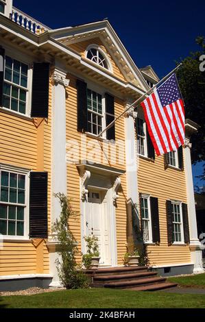 Eine amerikanische Flagge hängt vom historischen gelben Henry Wadsworth Longfellow in Cambridge, Massachusetts, in der Nähe von Boston Stockfoto