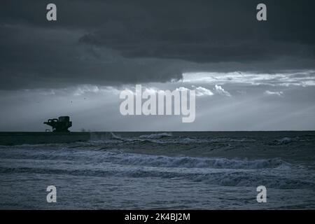 Dramatische Meereslandschaft mit Sonnenstrahlen. Leixoes Hafen Nordwand, nördlich von Portugal. Infrarotfilter verwendet. Getöntes Bkue. Stockfoto