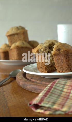 Bananenmuffins mit Butter auf einem Holztisch zum Frühstück. Stockfoto