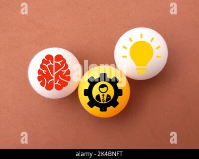 Ein Tischtennisball mit Ideen- und Gehirnsymbolen Stockfoto
