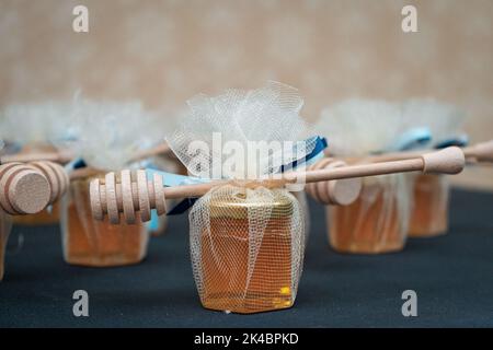 Einige kleine Gläser mit Honig gefüllt und in Tüll mit einem Honig Dipper auf sie gewickelt Stockfoto