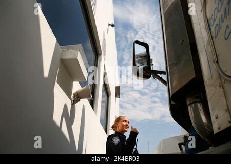 U.S. Customs and Border Protection Officer ist ein Daumen-hoch-Signal an einem Fahrer des Traktor-Anhänger tragen Einfuhren aus Mexiko, als er der US-Prüfpunkt der Cargo-Pre-Inspection-Anlage befindet sich auf der mexikanischen Seite Otay Mesa, Kalifornien/USA, Einreise, 22. Juni 2016 durchläuft. Jeden Tag mehrere hundert LKWs Line-up auf der mexikanischen Seite der Grenze, Importe in die USA zu liefern Eine wachsende Zahl von Reedereien sind CBPs Cargo Pre-Inspection zunutze, die vertrauenswürdigen Versendern schnellere und effizientere Mittel zur Lieferung der Produkte an US-Einzelhändler ermöglicht. CBP Pho Stockfoto