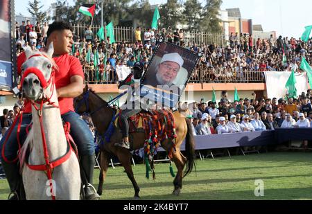 Gaza, Palästina. 01. Oktober 2022. Anhänger der palästinensischen Hamas-Bewegung halten ein Porträt des Vorsitzenden der Internationalen Vereinigung muslimischer Gelehrter, Yusuf al-Qaradawi, während sie an einer Kundgebung zur Unterstützung der al-Aqsa-Moschee in Jerusalem teilnehmen. Die Hamas organisierte eine Kundgebung, in der Israel dazu aufforderte, die Angriffe auf Palästinenser in Jerusalem und am Westufer zu stoppen, und sandte Botschaften, die Israel bedrohten, wenn es seine Angriffe fortsetzt. Kredit: SOPA Images Limited/Alamy Live Nachrichten Stockfoto