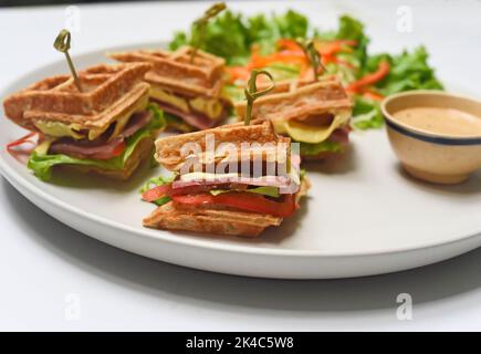 Belgische Waffeln auf weißem Teller mit grünem Nahaufnahme Stockfoto