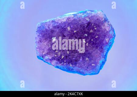 Ein Stück Amethyst (eine violette Quarzsorte) auf der hellen Oberfläche Stockfoto