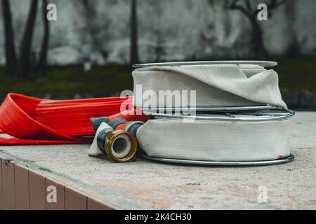 Alte rote und weiße alte Feuerschlauchspulen mit Bokeh-Hintergrund. Stockfoto