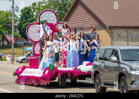 Eau Claire MI USA July 4 2022; Blossom Time Royalty winkt, während sie auf einem farbenfrohen Festwagen in dieser Festtagsparade reiten Stockfoto