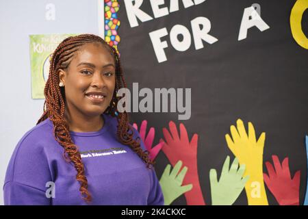 Ein Porträt einer lächelnden, selbstbewussten afroamerikanischen Lehrerin im Klassenzimmer, vertikal Stockfoto