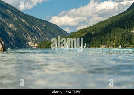 Ein See, der von bewaldeten Hügeln umgeben ist Stockfoto