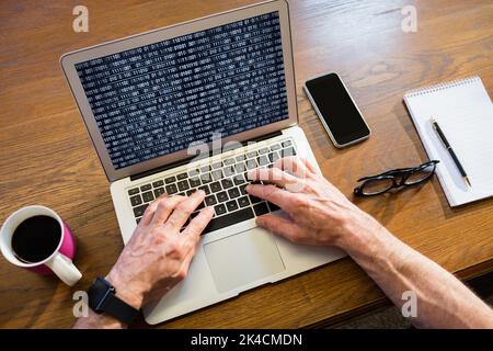 Geschäftsmann, der im Büro einen Laptop benutzt Stockfoto