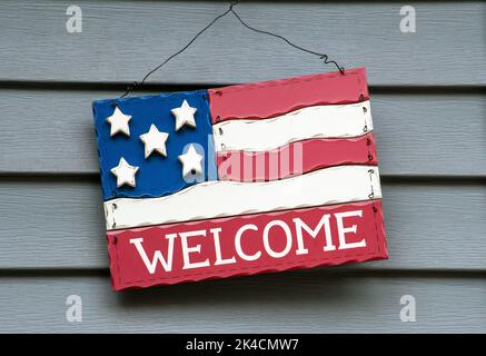 Eine dekorative amerikanische Flagge aus Holz hängt an der Seite eines Hauses vor der Haustür Stockfoto