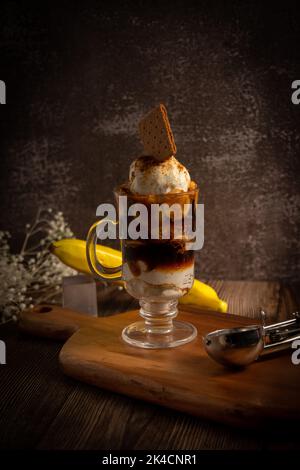 Eine vertikale Aufnahme eines köstlichen Eisdessertals mit einem Cookie darauf Stockfoto