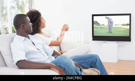 Paar sitzt auf der Couch zusammen Fernsehen zu Hause im Wohnzimmer Stockfoto