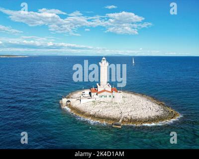 Eine Luftaufnahme der kleinen Insel mit Leuchtturm umgeben von Wasser in Porer Stockfoto