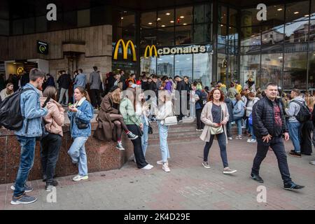 Kiew, Ukraine. 01. Oktober 2022. Nach der Wiedereröffnung der Kette in Kiew warten in der Nähe des McDonald's-Restaurants Menschen in der Schlange. Die Fast-Food-Kette McDonalds hat 10 Restaurants in Kiew wieder eröffnet und nimmt ihren Speisenservice wieder auf, erstmals nachdem sie ihre Restaurants im Februar 2022 aufgrund der russischen Invasion in der Ukraine geschlossen hatten. Kredit: SOPA Images Limited/Alamy Live Nachrichten Stockfoto