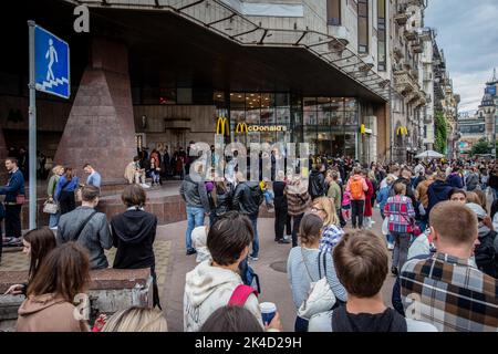 Kiew, Ukraine. 01. Oktober 2022. Nach der Wiedereröffnung der Kette in Kiew warten in der Nähe des McDonald's-Restaurants Menschen in der Schlange. Die Fast-Food-Kette McDonalds hat 10 Restaurants in Kiew wieder eröffnet und nimmt ihren Speisenservice wieder auf, erstmals nachdem sie ihre Restaurants im Februar 2022 aufgrund der russischen Invasion in der Ukraine geschlossen hatten. Kredit: SOPA Images Limited/Alamy Live Nachrichten Stockfoto