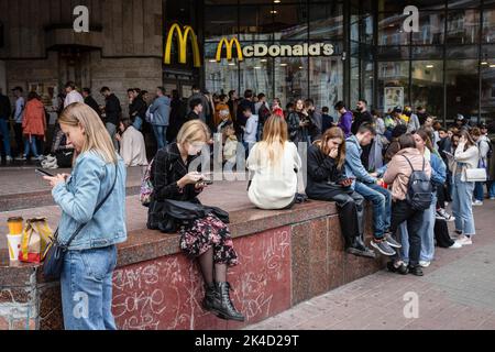 Kiew, Ukraine. 01. Oktober 2022. Nach der Wiedereröffnung der Kette in Kiew stehen Menschen mit eingekauften Speisen zum Mitnehmen in der Nähe des McDonald's-Restaurants. Die Fast-Food-Kette McDonalds hat 10 Restaurants in Kiew wieder eröffnet und nimmt ihren Speisenservice wieder auf, erstmals nachdem sie ihre Restaurants im Februar 2022 aufgrund der russischen Invasion in der Ukraine geschlossen hatten. Kredit: SOPA Images Limited/Alamy Live Nachrichten Stockfoto