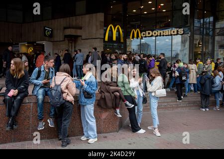 Kiew, Ukraine. 01. Oktober 2022. Nach der Wiedereröffnung der Kette in Kiew stehen Menschen mit eingekauften Speisen zum Mitnehmen in der Nähe des McDonald's-Restaurants. Die Fast-Food-Kette McDonalds hat 10 Restaurants in Kiew wieder eröffnet und nimmt ihren Speisenservice wieder auf, erstmals nachdem sie ihre Restaurants im Februar 2022 aufgrund der russischen Invasion in der Ukraine geschlossen hatten. Kredit: SOPA Images Limited/Alamy Live Nachrichten Stockfoto