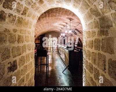 Ein kleiner Korridor führt zu einer geheimen Bar mit Hochstuhl und leisem Licht Stockfoto