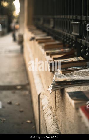 Vertikales Straßenbild von Büchern, die auf der Straße liegen. Stockfoto