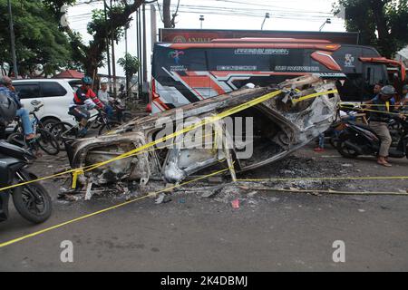 Malang, Indonesien. 1. Oktober 2022. Das am 2. Oktober 2022 aufgenommene Foto zeigt das Wrack eines verbrannten Autos vor dem Kanjuruhan-Stadion in Malang in der Provinz Ost-Java, Indonesien. Mindestens 129 Menschen wurden am Samstagabend bei einem Fußballspiel in der indonesischen Provinz Malang, Ost-Java, getötet und 180 weitere verletzt, wie die indonesische Polizei am Sonntag mitteilte. Quelle: Xinhua/Alamy Live News Stockfoto