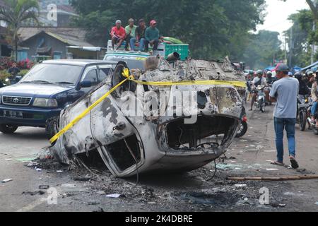 Malang, Indonesien. 1. Oktober 2022. Das am 2. Oktober 2022 aufgenommene Foto zeigt das Wrack eines verbrannten Autos vor dem Kanjuruhan-Stadion in Malang in der Provinz Ost-Java, Indonesien. Mindestens 129 Menschen wurden am Samstagabend bei einem Fußballspiel in der indonesischen Provinz Malang, Ost-Java, getötet und 180 weitere verletzt, wie die indonesische Polizei am Sonntag mitteilte. Quelle: Xinhua/Alamy Live News Stockfoto