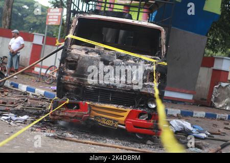 Malang, Indonesien. 1. Oktober 2022. Das am 2. Oktober 2022 aufgenommene Foto zeigt das Wrack eines verbrannten Lastwagens vor dem Kanjuruhan-Stadion in Malang in der Provinz Ost-Java, Indonesien. Mindestens 129 Menschen wurden am Samstagabend bei einem Fußballspiel in der indonesischen Provinz Malang, Ost-Java, getötet und 180 weitere verletzt, wie die indonesische Polizei am Sonntag mitteilte. Quelle: Xinhua/Alamy Live News Stockfoto