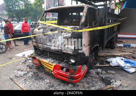 Malang, Indonesien. 1. Oktober 2022. Das am 2. Oktober 2022 aufgenommene Foto zeigt das Wrack eines verbrannten Lastwagens vor dem Kanjuruhan-Stadion in Malang in der Provinz Ost-Java, Indonesien. Mindestens 129 Menschen wurden am Samstagabend bei einem Fußballspiel in der indonesischen Provinz Malang, Ost-Java, getötet und 180 weitere verletzt, wie die indonesische Polizei am Sonntag mitteilte. Quelle: Xinhua/Alamy Live News Stockfoto