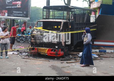 Malang, Indonesien. 1. Oktober 2022. Das am 2. Oktober 2022 aufgenommene Foto zeigt das Wrack eines verbrannten Lastwagens vor dem Kanjuruhan-Stadion in Malang in der Provinz Ost-Java, Indonesien. Mindestens 129 Menschen wurden am Samstagabend bei einem Fußballspiel in der indonesischen Provinz Malang, Ost-Java, getötet und 180 weitere verletzt, wie die indonesische Polizei am Sonntag mitteilte. Quelle: Xinhua/Alamy Live News Stockfoto