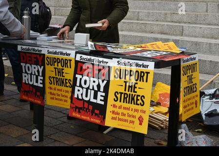 Tisch mit Plakaten, Büchern und Merchandise beim Enough is Enough protestmarsch in Portsmouth, England. Stockfoto