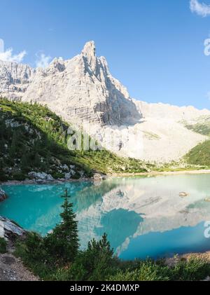 Atemberaubende Aussicht auf den See Sorapis (Lago di Sorapis) mit seinem türkisfarbenen Wasser, umgeben von einem Wald und schönen felsigen Bergen, Dolomiten, Italien. Stockfoto