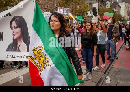 San Francisco, Usa. 01. Oktober 2022. Menschen marschieren auf der Straße von San Francisco mit Plakaten und der Flagge des Iran. Nach dem Tod des iranischen Mädchens Mahsa Amini fanden weltweit Proteste und Kundgebungen zur Unterstützung des Irans statt. In San Francisco versammeln sich Tausende von Menschen und marschieren auf der Straße mit Fotos von Mahsa Amini, Spruchbändern, Plakaten und der Flagge des Iran. Menschen, die an der Kundgebung teilnehmen, denken, dass jeder den Iraner unterstützen sollte, und sie rufen während der Kundgebung „Frau, Leben, Freiheit“. Kredit: SOPA Images Limited/Alamy Live Nachrichten Stockfoto