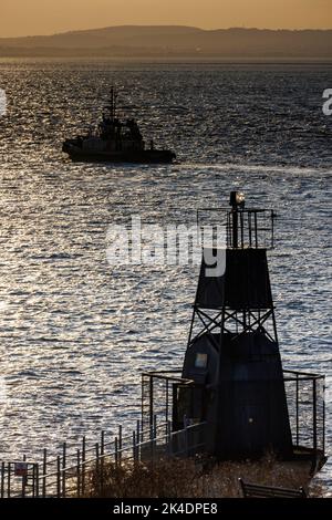 Schlepper in Silhouette wartet auf Schiff in den Hafen zu nehmen Stockfoto