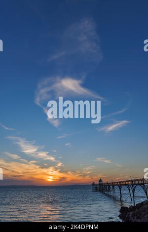 Clevedon Pier bei Sonnenuntergang mit der Sonne über der walisischen Küste Stockfoto