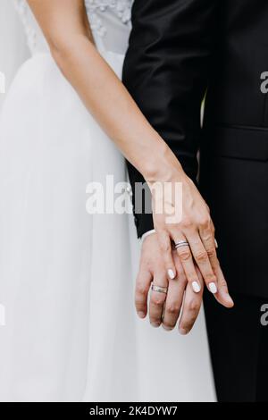 Hochzeit Nahaufnahme Porträt der Hände und Finger mit goldenen Ringen der Braut und Bräutigam bei einer Zeremonie im Freien Stockfoto