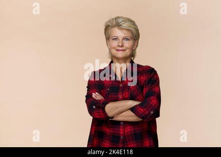 Fantastisch und freundlich lächelnde blonde Frau im schönen kariertes Hemd studio Shot, isoliert Stockfoto