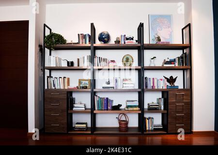 Bücherregal aus Metall und Holz, mit Schubladen Person vor der Tür Stockfoto