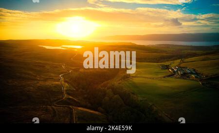 Eine Luftaufnahme des Flusses Clyde, der bei Sonnenuntergang durch die Berge Schottlands fließt Stockfoto