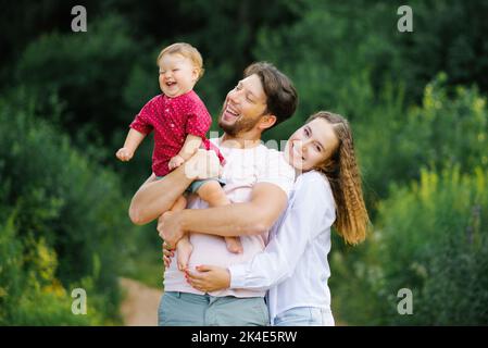 Glückliche junge schöne Familie mit einem jungen Sohn genießt einen schönen Tag im Sommerpark Stockfoto