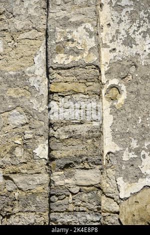 Struktur der Wand des alten Gebäudes mit eingestürzter Gips, Rissen und Vertiefungen. Hintergrund einer schäbigen Gebäudeoberfläche. Zerstörte Mauer mit umgestürzten Plas Stockfoto