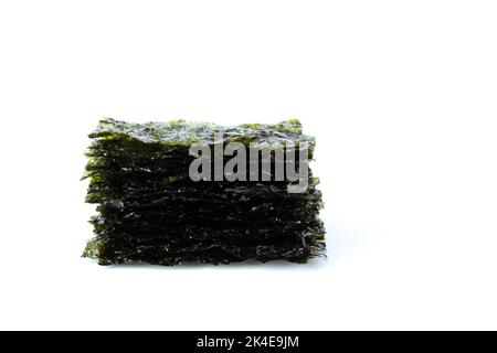 Gewürzter Seetang-Snack. Algenblätter in einem Stapel auf weißem Hintergrund gestapelt. Stockfoto