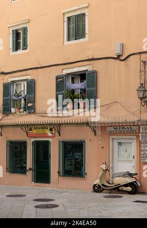 Korfu, Griechenland. 02. September 2022: Blick auf eine typische schmale Straße in der Altstadt von Korfu. Geparkter Roller, Motorrad. Stockfoto