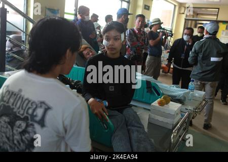 Malang, Indonesien. 2. Oktober 2022. Verletzte werden in einem Krankenhaus in Malang in der Provinz Ost-Java, Indonesien, medizinisch behandelt, 2. Oktober 2022. Laut dem stellvertretenden Gouverneur der Provinz Emil Dardak hat die Zahl der Todesopfer bei einem Fußballspiel in der indonesischen Provinz Ost-Java am Sonntagnachmittag bei 174 gelegen. Die Tragödie ereignete sich am Samstagabend im Kanjuruhan-Stadion in Malang in der indonesischen Provinz Ost-Java, direkt nachdem der Verein Arema Malang bei einem Fußballspiel der indonesischen Liga gegen Persebaya Surabaya verloren hatte. Quelle: Bayu Novanta/Xinhua/Alamy Live News Stockfoto