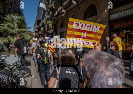 Barcelona, Spanien. 01. Oktober 2022. Während der Demonstration wird ein Unabhängigkeitsproter mit einem Plakat gesehen. Tausende von Menschen haben an der Feier der Gedenkakte zum fünften Jahrestag des Referendums vom 1. Oktober in Katalonien teilgenommen, das von den Sicherheitskräften und Organen des spanischen Staates stark unterdrückt wurde. (Foto von Paco Freire/SOPA Images/Sipa USA) Quelle: SIPA USA/Alamy Live News Stockfoto