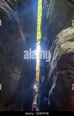 Waldbillig: Wanderer in enger Passage zwischen den Felsen Rittergang in der Kleinen Schweiz (Petite Suisse Luxembourgeoise, kleine Luxemburger Schweiz) in Stockfoto