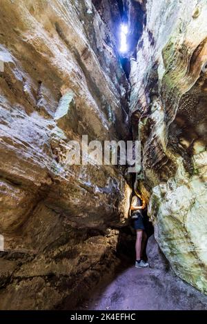 Waldbillig: Wanderer in enger Passage zwischen den Felsen Rittergang in der Kleinen Schweiz (Petite Suisse Luxembourgeoise, kleine Luxemburger Schweiz) in Stockfoto